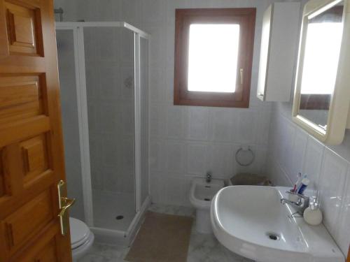 ein Badezimmer mit Dusche, Waschbecken und Toilette in der Unterkunft Luminosa villa con vistas al mar en Cala Moraig in Benitatxell