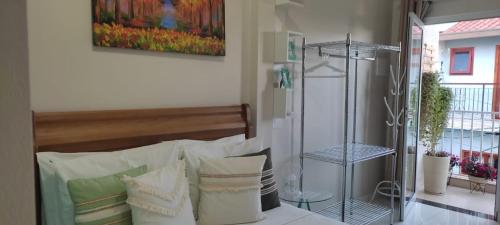 a bedroom with a bed with white pillows at Hospedagem Quarto Chic centro Cunha in Cunha