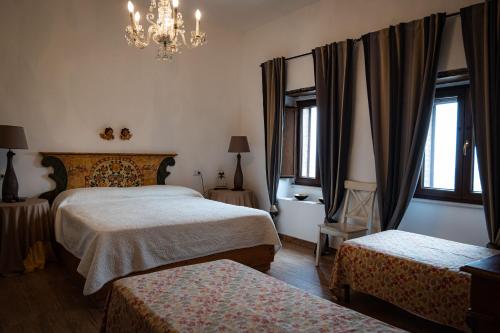 a hotel room with two beds and a chandelier at Country Relais La Torretta Baronale in San Giorgio Montagna
