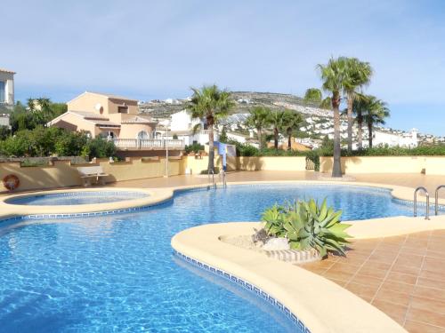 ein Swimmingpool in einem Resort mit Palmen in der Unterkunft Luminosa villa con vistas al mar en Cala Moraig in Benitatxell