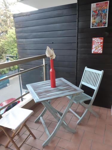 una mesa, una silla y un jarrón en el patio en UBAYE.MEXICO, en Barcelonnette
