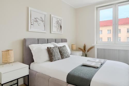 - une chambre avec un grand lit blanc et une fenêtre dans l'établissement Alfama Garden, à Grudziądz