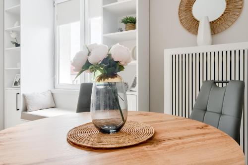 a vase of flowers sitting on a wooden table at Alfama Garden in Grudziądz