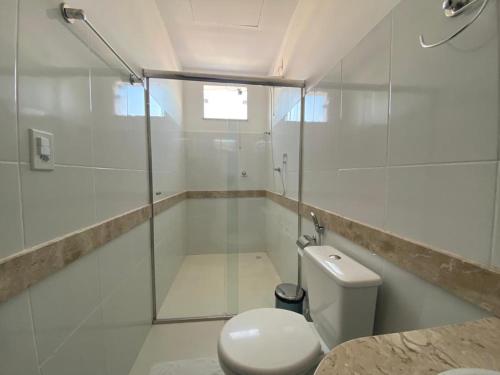 a bathroom with a toilet and a glass shower at Pousada Santos in Parintins