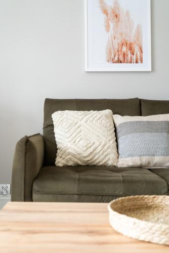 a brown couch in a living room with a table at Alfama Garden in Grudziądz