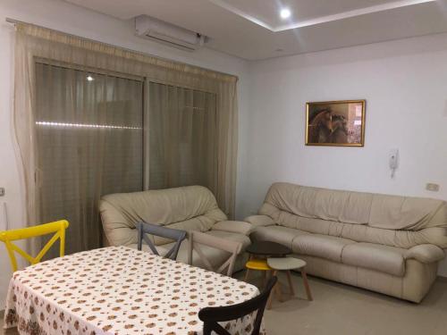 ein Wohnzimmer mit einem Sofa und einem Tisch in der Unterkunft Luxurious appart Sousse chat meriem with sea view in Sousse