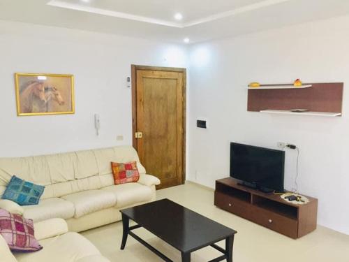 ein Wohnzimmer mit einem Sofa und einem TV in der Unterkunft Luxurious appart Sousse chat meriem with sea view in Sousse