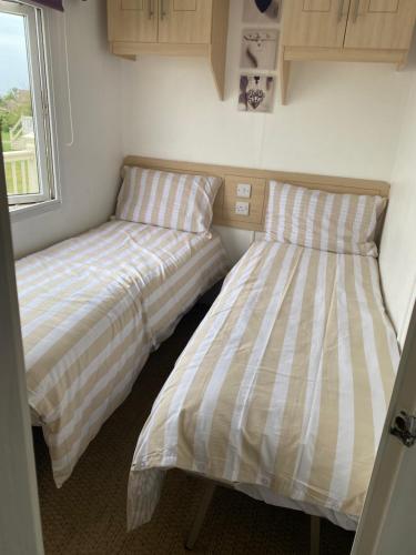 two beds sitting next to each other in a room at ChaletAway in Leysdown-on-Sea