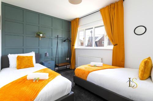 two beds in a small room with orange curtains at Luke Stays Hill Crest Esh Durham in Durham