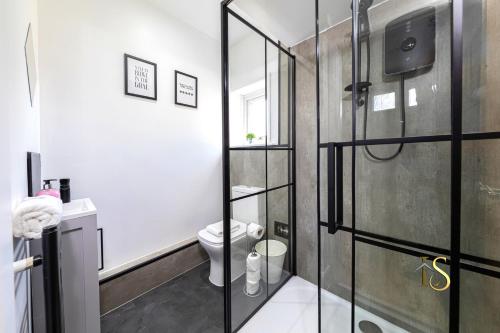 a bathroom with a toilet and a glass shower at Luke Stays Hill Crest Esh Durham in Durham