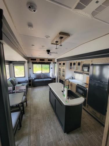an rv with a kitchen and a living room at Noah's Ark Campground in Revelstoke