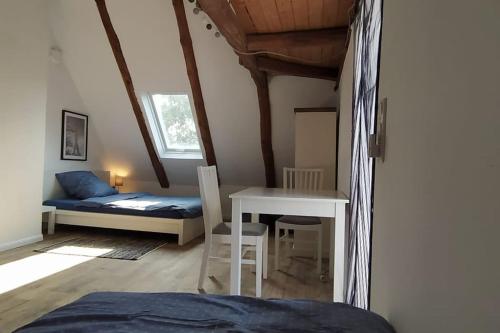een slaapkamer met een bed, een bureau en een tafel bij FairSchlafen-Dachstudio in Bücken