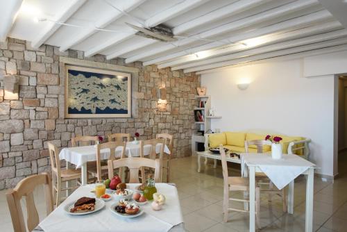 a dining room with tables and chairs and a brick wall at Tania Milos in Pollonia