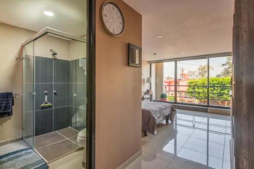 La salle de bains est pourvue d'une douche et d'une horloge murale. dans l'établissement S44 EXCELENTE MINI DEPA A 100 MTS CAMINANDO DEL ITESM CEM, à Mexico