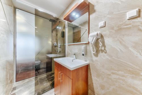 y baño con lavabo y ducha. en Hotel BH en Dobra Voda