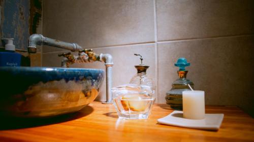 a counter with a bowl and a candle and a sink at Inti, hospedaje de campo. in Bartolomé Mitre