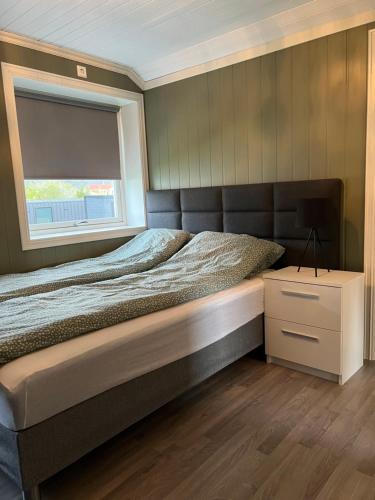 a bedroom with a large bed and a window at Et koselig hus i vakre Lofoten in Stamsund