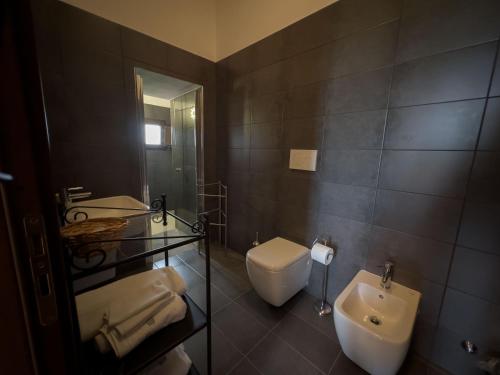 a bathroom with a sink and a toilet and a mirror at Country Relais La Torretta Baronale in San Giorgio Montagna
