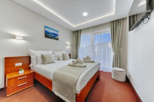 Un dormitorio con una cama grande y una ventana en Hotel BH, en Dobra Voda