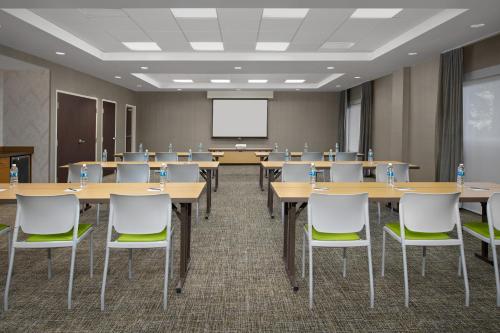 a conference room with tables and chairs and a projection screen at SpringHill Suites by Marriott Portland Vancouver in Vancouver
