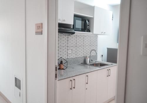 a kitchen with white cabinets and a sink at Coolspace @ SMDC Wind Residence Budget, WIFI, NETFLIX in Tagaytay