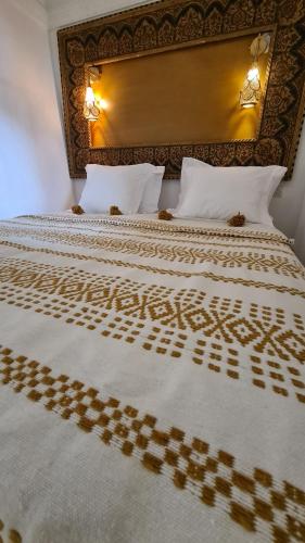 een slaapkamer met een bed met een bruine en witte sprei bij Riad la Cigale in Marrakesh