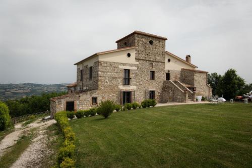 a large stone building on a grassy hill at Country Relais La Torretta Baronale in San Giorgio Montagna
