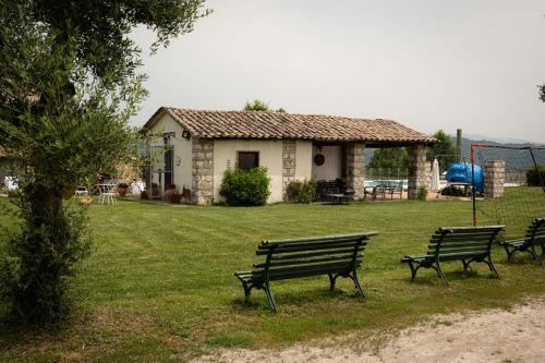 three park benches in a yard with a house at Country Relais La Torretta Baronale in San Giorgio Montagna