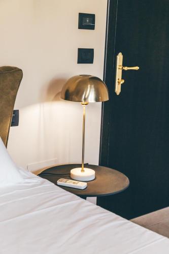a lamp sitting on a table next to a bed at Eksōtika in Oliveri