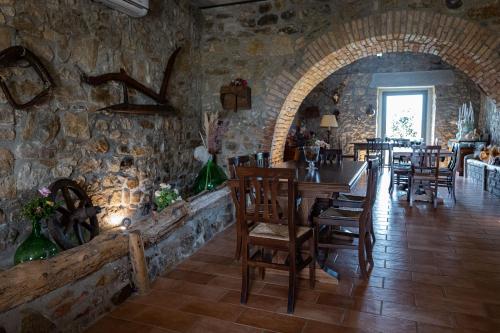 a restaurant with a table and chairs in a stone wall at Country Relais La Torretta Baronale in San Giorgio Montagna