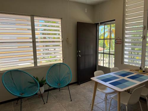a dining room with a table and chairs and windows at 2-BR Modern Oceanfront Apt Steps from Playa Sucia in Cabo Rojo
