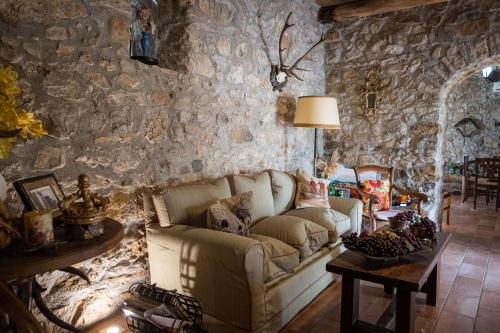 a living room with a couch and a stone wall at Country Relais La Torretta Baronale in San Giorgio Montagna