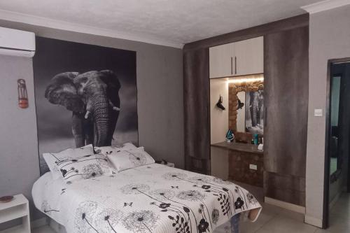 a bedroom with an elephant painting on the wall at Stone House - we have backup power supply in Lusaka