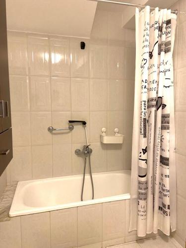 a bathroom with a tub and a shower curtain at Casa Concha do Caserón do Viaxeiro in Mondoñedo