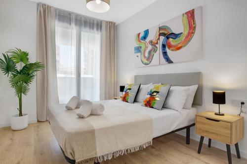 - une chambre avec un grand lit blanc et un palmier dans l'établissement Terralmar Beach & City, à Malaga