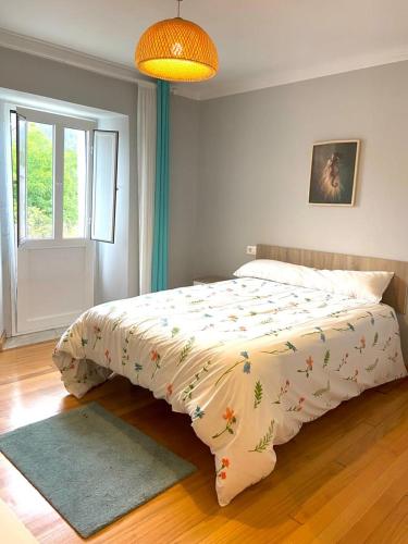 Un dormitorio con una cama con una manta. en Casa Concha do Caserón do Viaxeiro en Mondoñedo