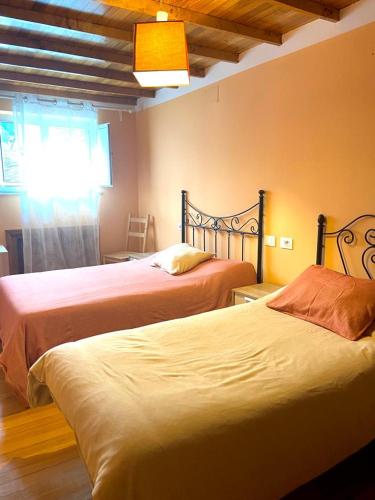 1 dormitorio con 2 camas y ventana en Casa Concha do Caserón do Viaxeiro en Mondoñedo