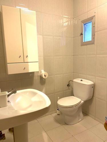 a white bathroom with a toilet and a sink at Casa Concha do Caserón do Viaxeiro in Mondoñedo