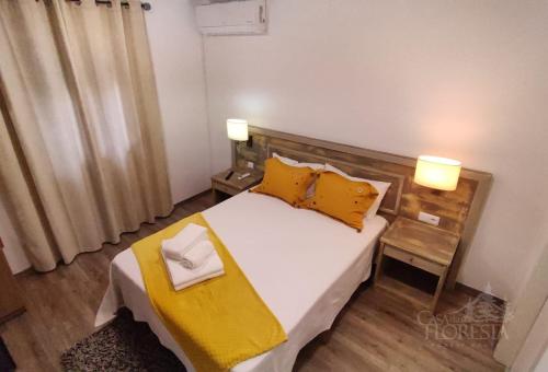 a bedroom with a large bed with yellow pillows at Casa da Floresta in Covilhã