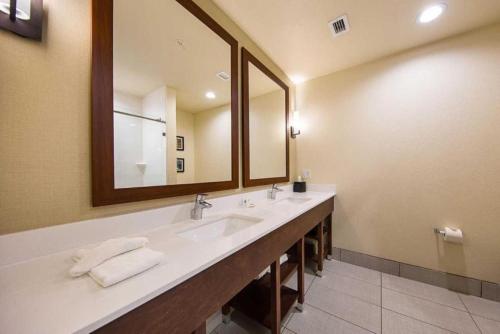 a bathroom with two sinks and a large mirror at Comfort Suites Greenville South in Piedmont