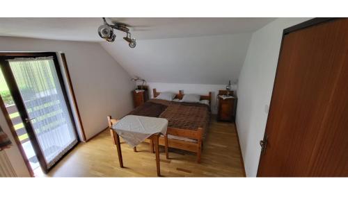 1 dormitorio con cama, mesa y ventana en Počitniška hiša pr Puc en Mojstrana
