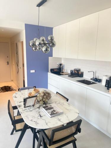 a kitchen with a table and chairs and a kitchen with white cabinets at Picasso Apartament in Tavira