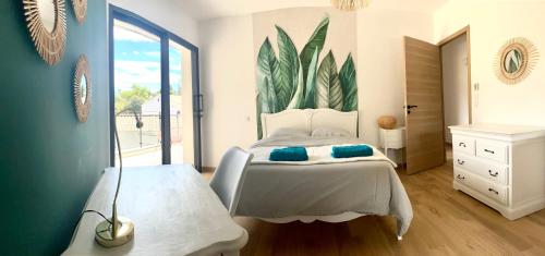 ein Schlafzimmer mit einem Bett mit blauen Kissen darauf in der Unterkunft Villa d’exception Montpellier in Saint-Jean-de-Védas