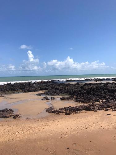 een strand met rotsen en de oceaan op de achtergrond bij Casa_Mare11 in São Miguel do Gostoso