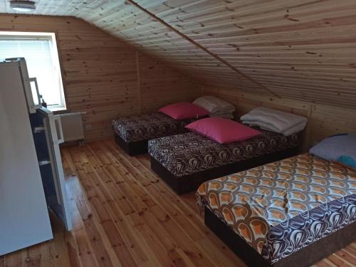 three beds in a room with wooden floors at Kwatera u Stasia in Szczebrzeszyn