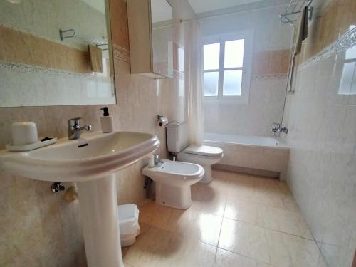 a bathroom with a sink and a toilet and a tub at Casa Atlantica Golf & Sea view in Caleta De Fuste