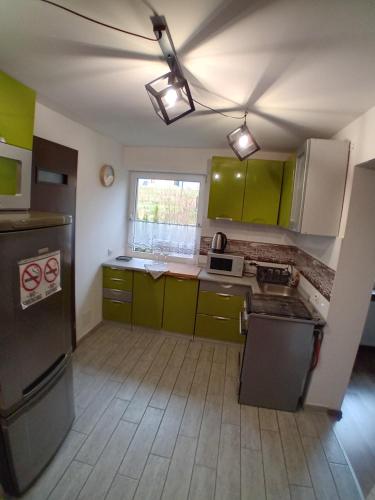 an empty kitchen with green cabinets and a window at Apartament nad Bukówką in Lubawka