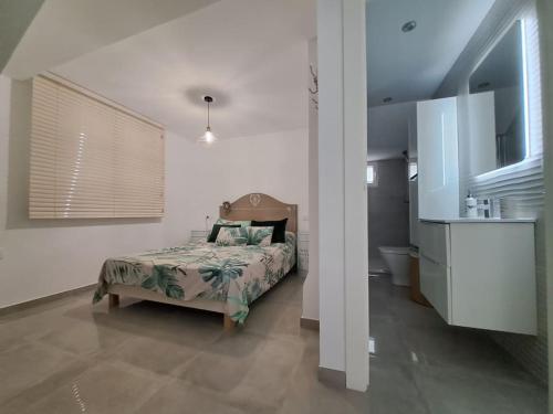 - une chambre avec un lit et une salle de bains dans l'établissement Nueva Almería beach & chill, à Almería