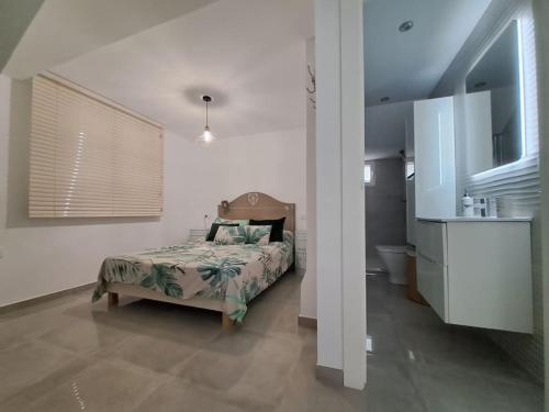 a bedroom with a bed and a bathroom at Nueva Almería beach & chill in Almería