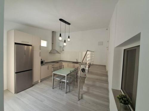 a kitchen with a table and chairs and a refrigerator at Nueva Almería beach & chill in Almería